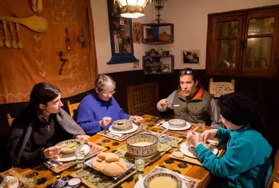 a group of people sitting around a table eating at Dar KamalChaoui in Bhalil