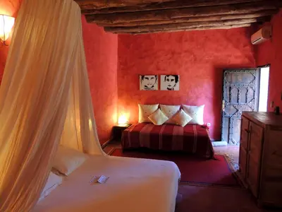 a red bedroom with two beds and a window at Dar Qamar in Agdz