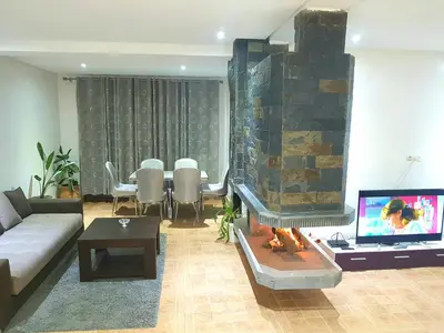 a living room with a couch and a fire place at Chalet Asmoun in Imouzzer Kandar