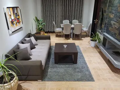 a living room with a couch and a table at Chalet Asmoun in Imouzzer Kandar
