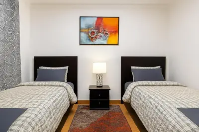 a bedroom with two beds and a lamp on a table at Chalet Asmoun in Imouzzer Kandar