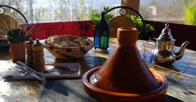 a table with a bowl of food and a bottle at Camping Auberge Zebra in Ouzoud