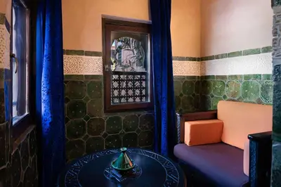 a room with a table and a chair and a window at Hôtel Riad Dar Daïf in Ouarzazate