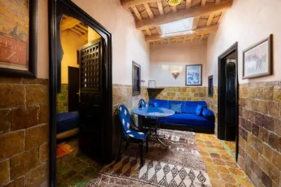 a room with a blue couch and a table at Hôtel Riad Dar Daïf in Ouarzazate