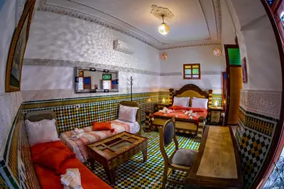 a room with a couch and a bed and a table at Riad Eloria Fes in Fès
