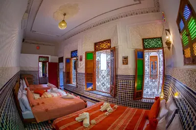 a room with two beds and stained glass windows at Riad Eloria Fes in Fès