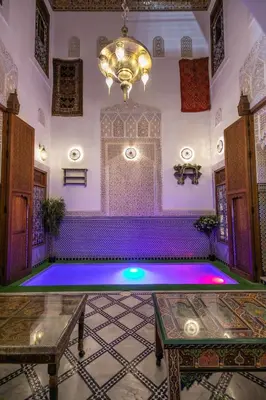 an indoor pool in a room with purple lighting at Riad Eloria Fes in Fès