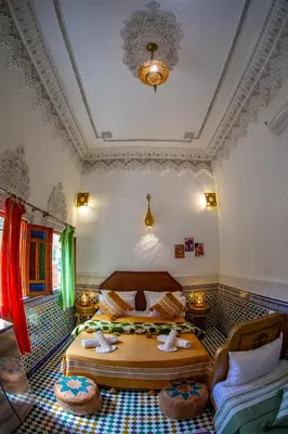a bedroom with two beds in a room with a ceiling at Riad Eloria Fes in Fès
