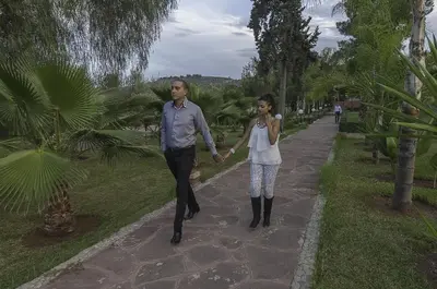 a man and woman walking down a path holding hands at Hotel Dar Eddaya in Khemisset