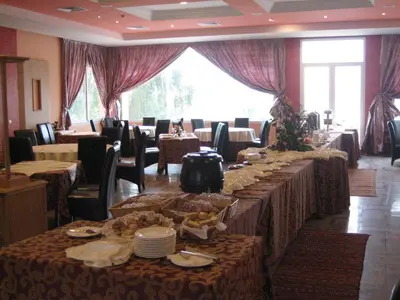 a dining room with long tables with plates and dishes at Hotel Dar Eddaya in Khemisset