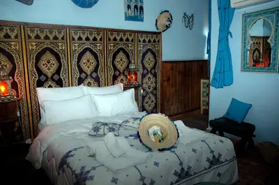 a bedroom with a large bed with a large headboard at Riad Lahboul in Meknès