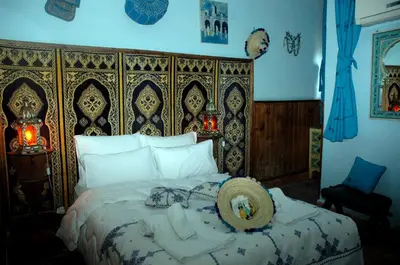 a bedroom with a large bed with a large headboard at Riad Lahboul in Meknès