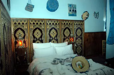a bedroom with a bed with a wooden head board at Riad Lahboul in Meknès