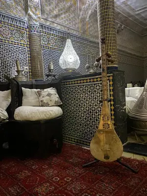 a guitar in a room with a bed and a ceiling at Riad Lahboul in Meknès