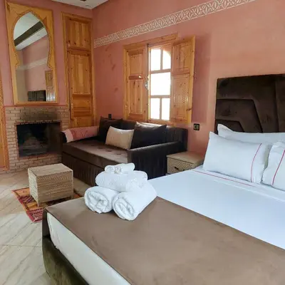 a bedroom with a bed and a living room at Chez Mamouchthka in Ourika