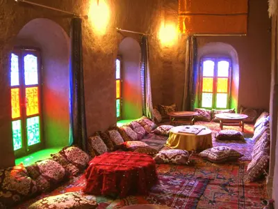 a living room with couches and a table and windows at Kasbah Oulad Othmane in Agoubt