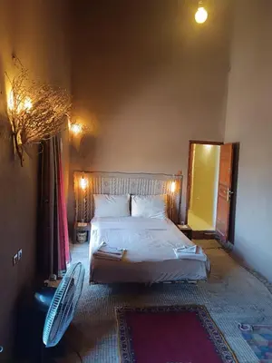 a bedroom with a bed and a mirror at Kasbah Oulad Othmane in Agoubt