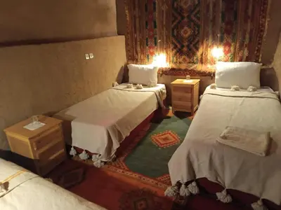 a small room with two beds and a rug at Kasbah Oulad Othmane in Agoubt