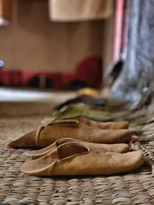 a row of brown shoes sitting on a table at Kasbah Oulad Othmane in Agoubt