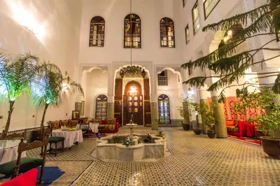 a large room with tables and chairs in a building at Riad Lalla Zoubida in Fès