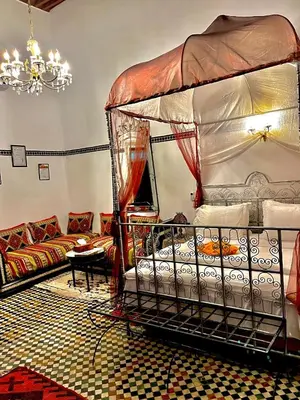 a living room with a bed and a couch at Riad Lalla Zoubida in Fès