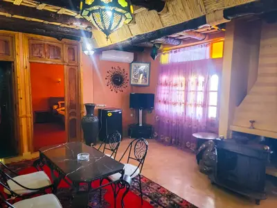 a living room with a table and chairs and a chandelier at Hotel Taddart in Midelt