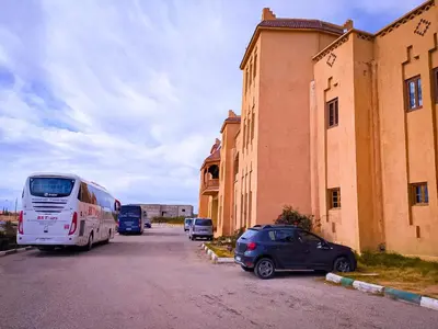 a bus parked in a parking lot next to a building at Hotel Taddart in Midelt