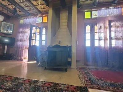 a room with a fireplace and a room with windows at Hotel Taddart in Midelt