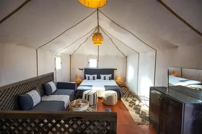 a bedroom with a bed and a couch in a room at DWO Golden Camp Merzouga in Merzouga