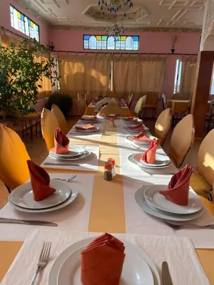 a long table with red napkins and plates on it at Diyar Timnay in Moulay Idriss Zerhoun