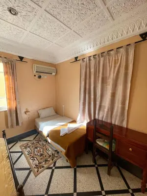 a small bedroom with a bed and a window at Diyar Timnay in Moulay Idriss Zerhoun