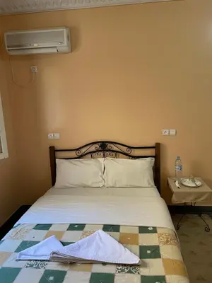 a bedroom with a bed and a air conditioner on the wall at Diyar Timnay in Moulay Idriss Zerhoun