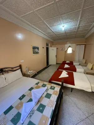 a bedroom with two beds and a couch at Diyar Timnay in Moulay Idriss Zerhoun