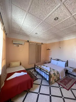 a room with two beds and a ceiling at Diyar Timnay in Moulay Idriss Zerhoun