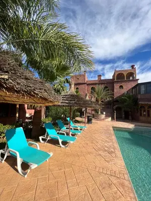 a row of blue lounge chairs next to a swimming pool at Palais D'Ouzoud in Azilal