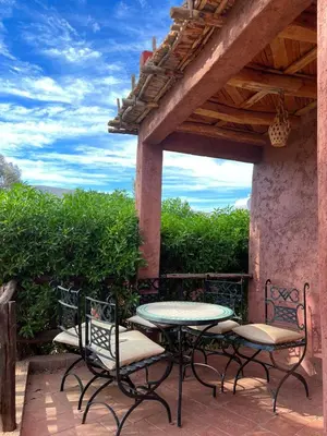 a patio with a table and chairs on a porch at Palais D'Ouzoud in Azilal