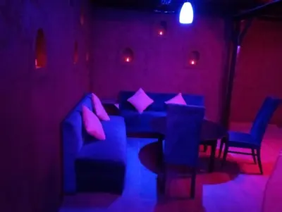 a purple room with a couch and a table and chairs at Palais D'Ouzoud in Azilal