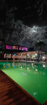 a building with a pool of green water at night at Palais D'Ouzoud in Azilal