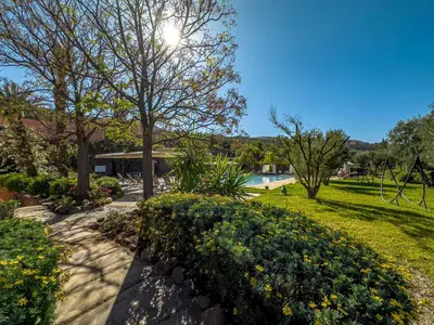 a garden with a swimming pool and trees and bushes at Kasbah Agounsane Hotel & Spa in Ourika