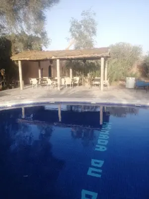 a swimming pool with a gazebo in the background at Hamada Du Draa in Mhamid