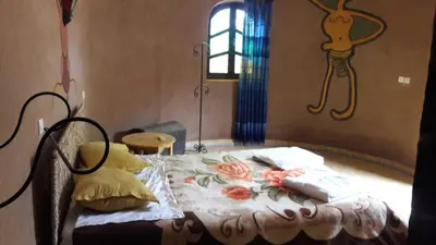 a bedroom with a bed with a blanket and pillows at Hamada Du Draa in Mhamid