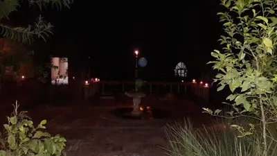 a night time view of a patio with a fountain at Hamada Du Draa in Mhamid