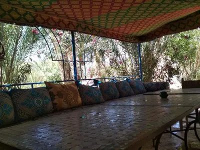 a long table with a bunch of pillows on it at Hamada Du Draa in Mhamid