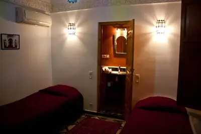 a room with two beds and a mirror on the wall at Riad Tayba in Fès