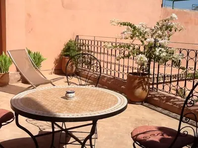 a patio with a table and chairs and flowers at Riad Tayba in Fès