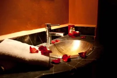 a bathroom sink with red flowers on a counter at Riad Tayba in Fès