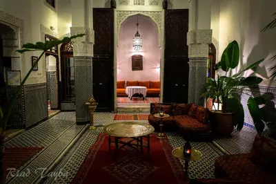 a lobby with a table and chairs in a building at Riad Tayba in Fès