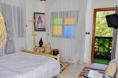 a bedroom with a bed and a tv and a window at Hotel Safari Week end in Midelt