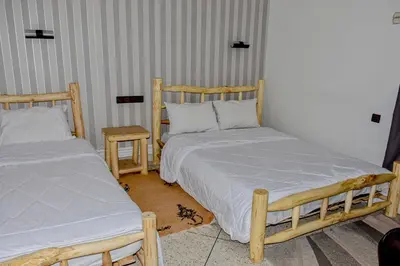 a bedroom with two beds and a table at Hotel Safari Week end in Midelt