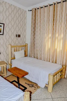 a bedroom with two beds and a table at Hotel Safari Week end in Midelt